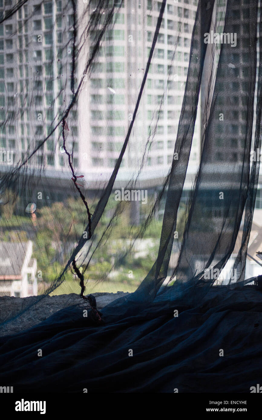 View looking out through construction safety netting in an abandoned building, Bangkok, Thailand. Stock Photo