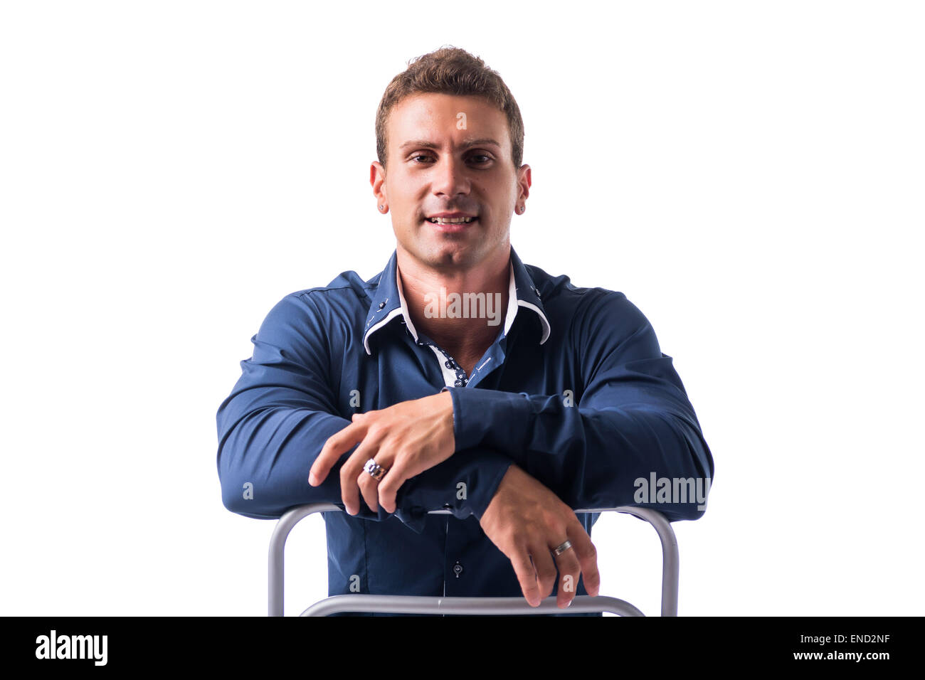 Smiling young man sitting on chair backwards Stock Photo Alamy