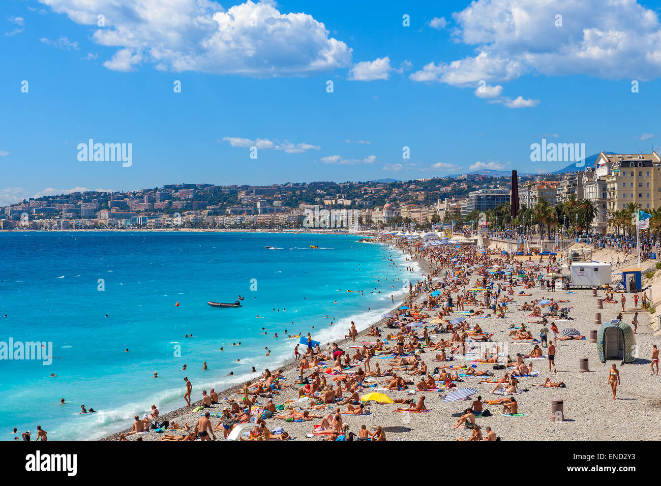 People on beach along seashore and Promenade des Anglais in Nie, France. Stock Photo