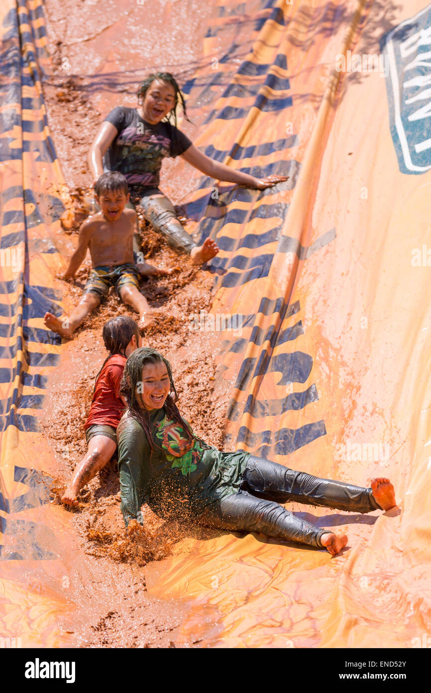 A group slips down a mud slide during the 2015 National Red Neck Championships May 2, 2015 in Augusta, Georgia. Hundreds of people joined in a day of country sport and activities. Stock Photo