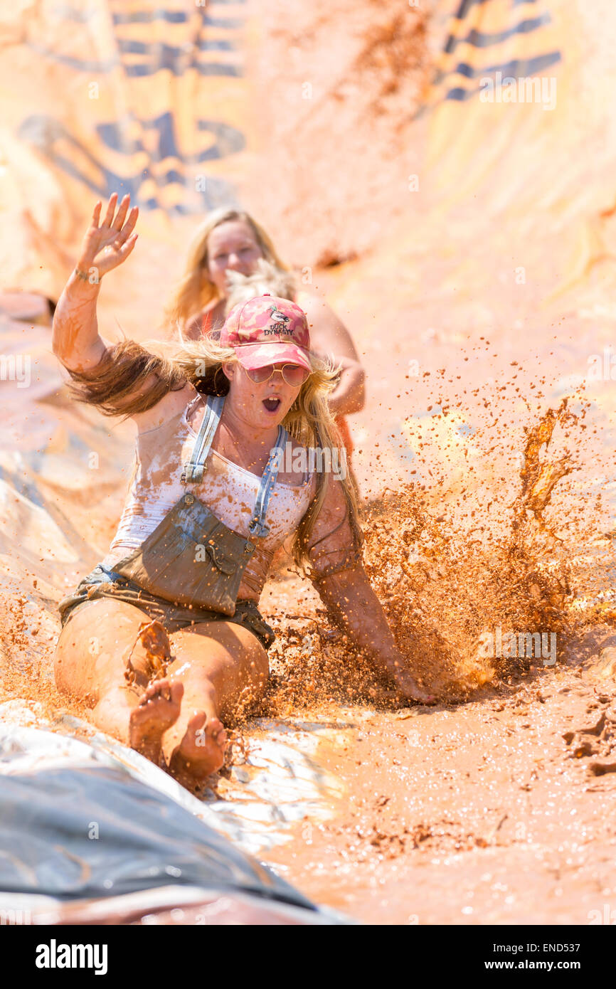A group of children slip down a mud slide during the 2015 National Red Neck Championships May 2, 2015 in Augusta, Georgia. Hundreds of people joined in a day of country sport and activities. Stock Photo