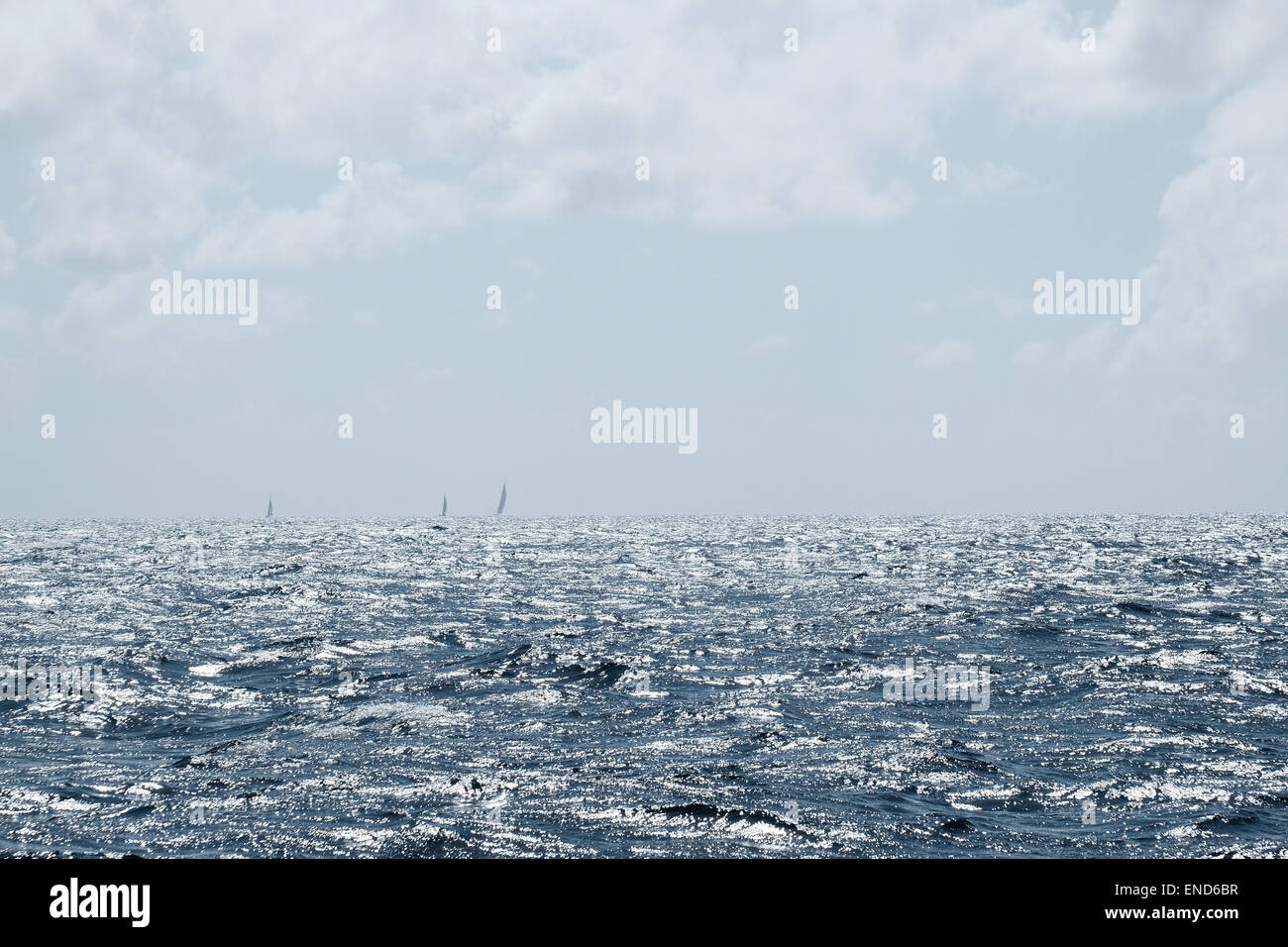 Ocean waves with several sailing yachts on the horizon Stock Photo