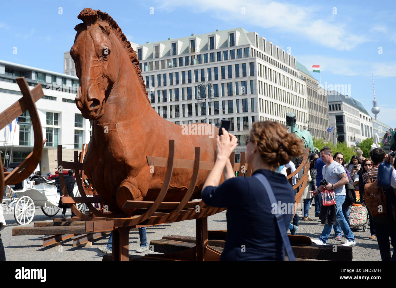 Berlin, Germany. 03rd May, 2015. A woman photographs the horse sculptures of the Mexcican artist Gustavo Aceves in front of the Brandenburg gate in Berlin, Germany, 03 May 2015. 'Lapidarium - overcoming borders' - under this motto the Mexican wants to refer back to the quadriga horse and carriage on the gate using archaelogical remains to build the sculptures. Photo: BRITTA PEDERSEN/dpa/Alamy Live News Stock Photo