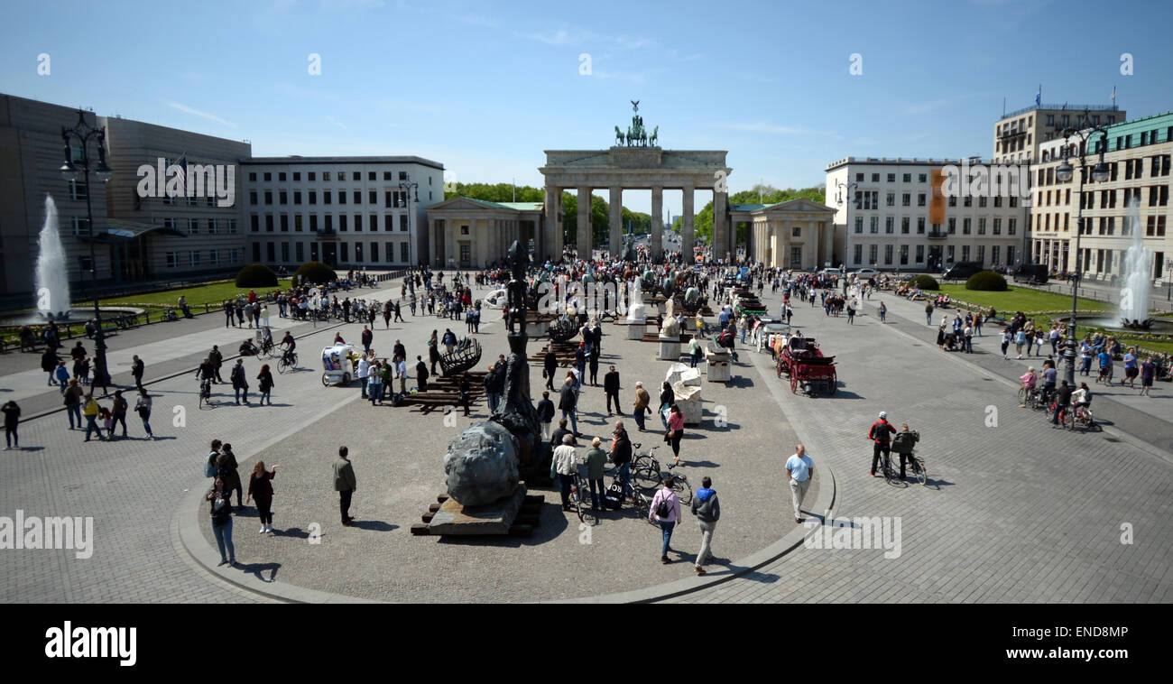Berlin, Germany. 03rd May, 2015. Pedestrians examine the horse sculptures of the Mexcican artist Gustavo Aceves in front of the Brandenburg gate in Berlin, Germany, 03 May 2015. 'Lapidarium - overcoming borders' - under this motto the Mexican wants to refer back to the quadriga horse and carriage on the gate using archaelogical remains to build the sculptures. Photo: BRITTA PEDERSEN/dpa/Alamy Live News Stock Photo