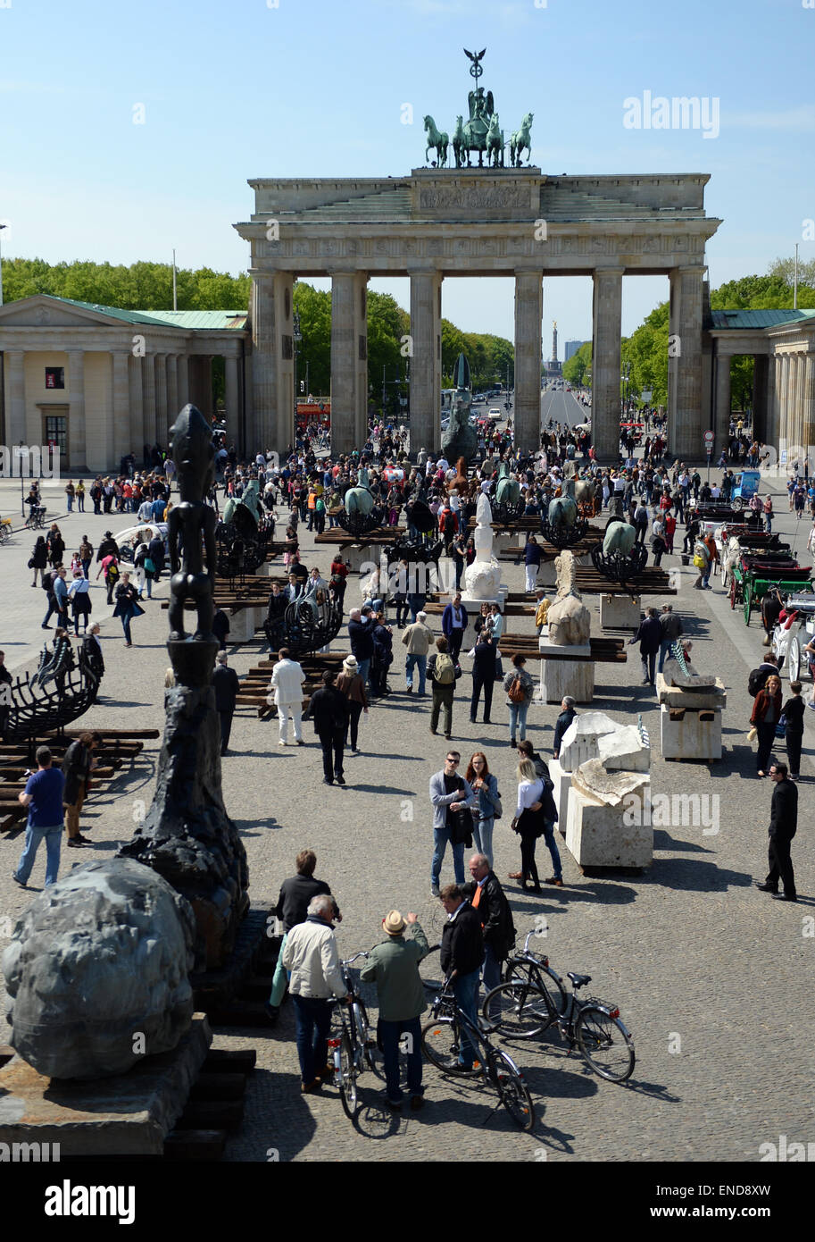 Berlin, Germany. 03rd May, 2015. Pedestrians examine the horse sculptures of the Mexcican artist Gustavo Aceves in front of the Brandenburg gate in Berlin, Germany, 03 May 2015. 'Lapidarium - overcoming borders' - under this motto the Mexican wants to refer back to the quadriga horse and carriage on the gate using archaelogical remains to build the sculptures. Photo: BRITTA PEDERSEN/dpa/Alamy Live News Stock Photo