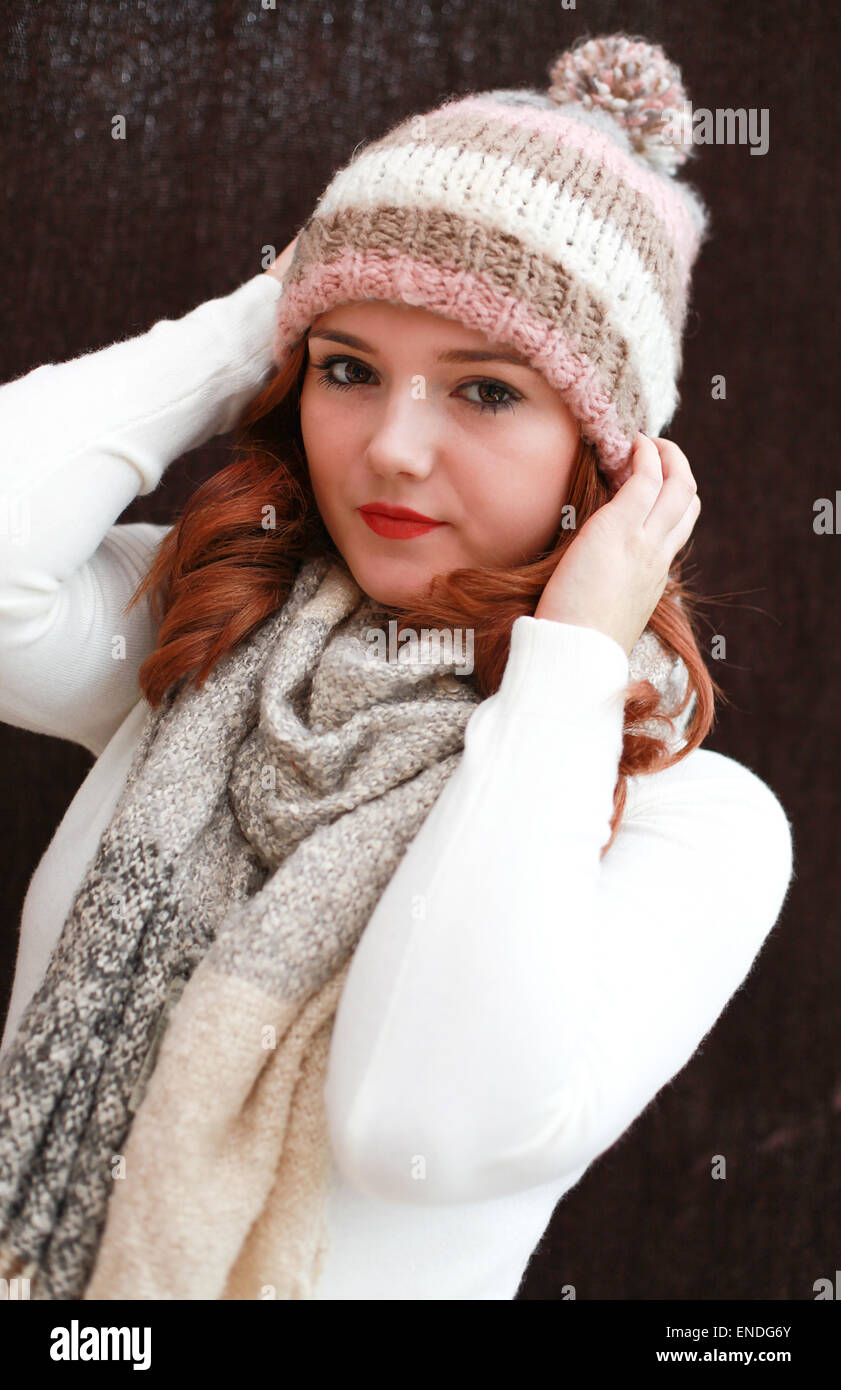 Portrait of a pretty teenage girl with red hair holding on to her hat Stock Photo