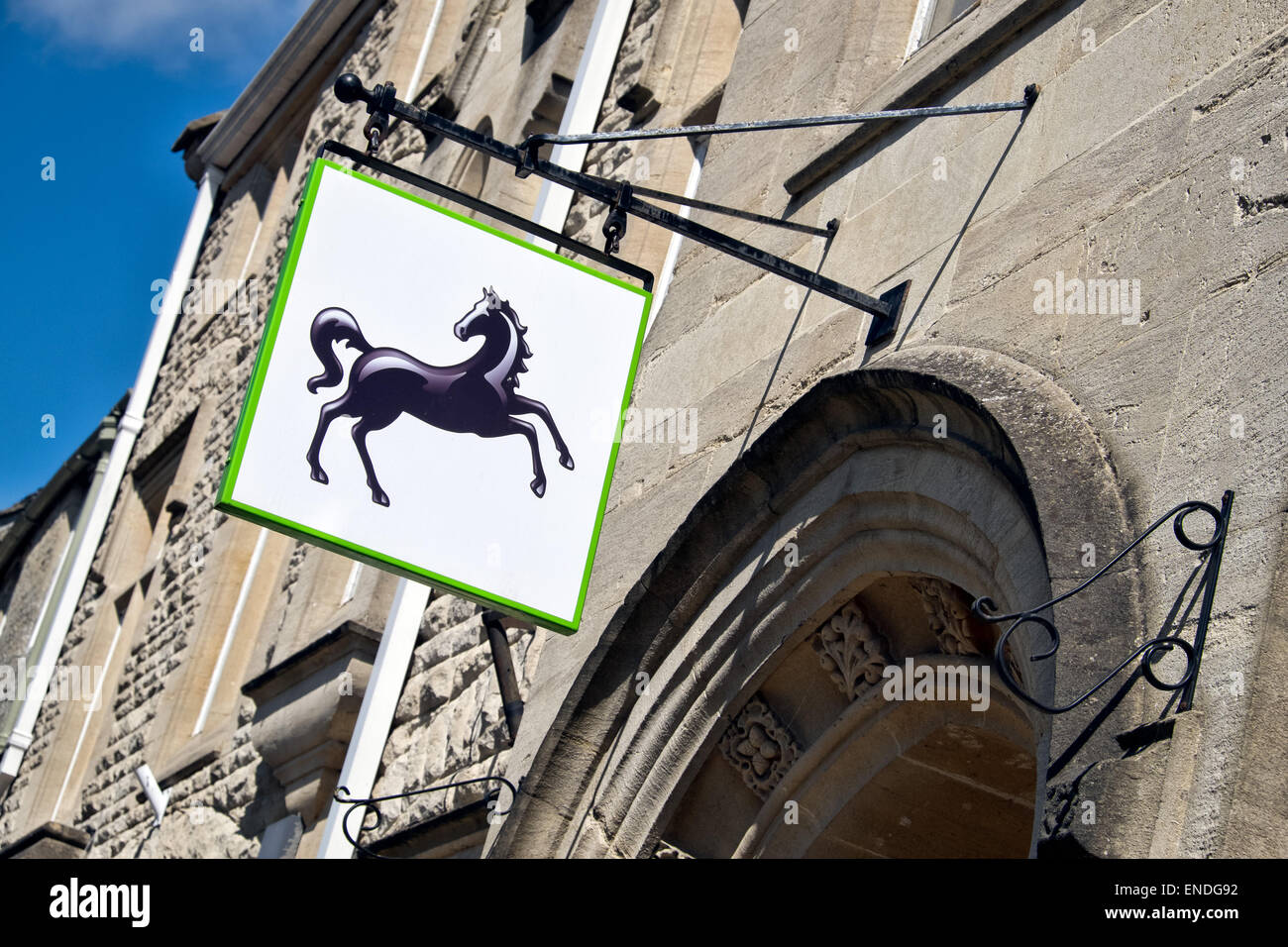 The Lloyds bank black horse sign hanging, displayed over the entrance,outside a UK branch on a sunny day Stock Photo