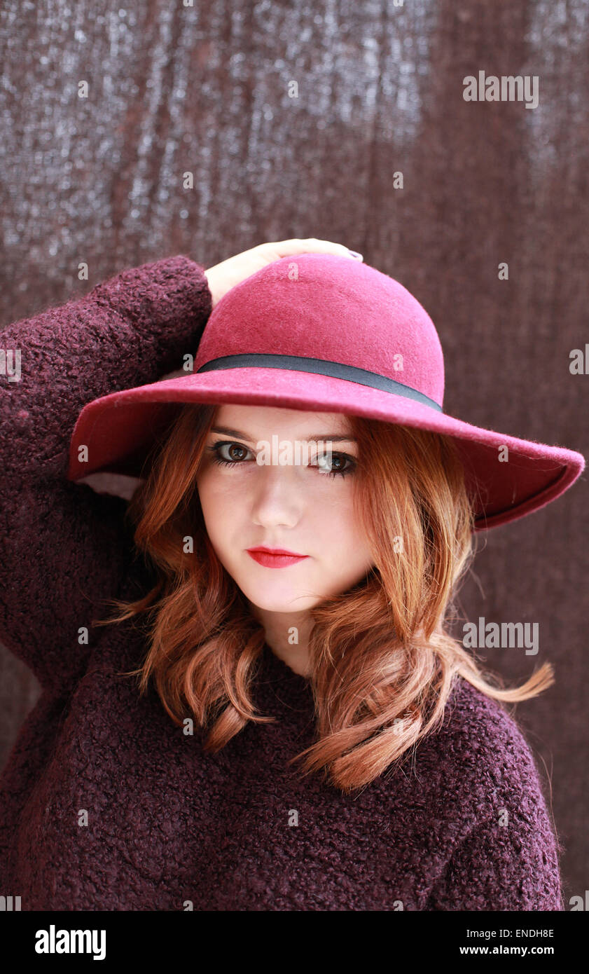 Portrait of a pretty teenage girl with red hair wearing a chunky jumper and hat Stock Photo