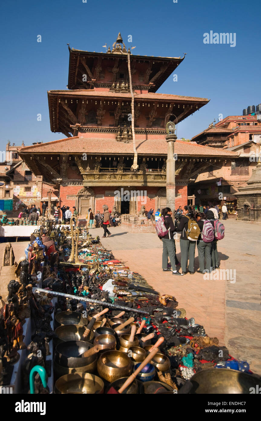 NEPAL, Kathmandu, Patan, Durbar Square, Bhimsen Hindu Temple (rebuilt 1682) with Lion Statue on a  column and market stall Stock Photo