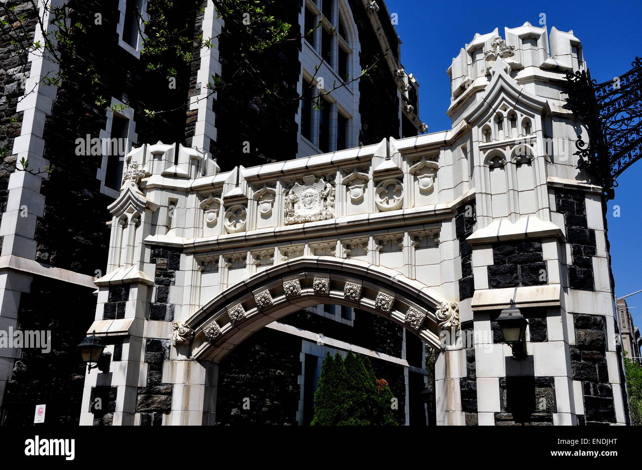 New York City City College neogothic gateway arch with carved rosettes, shields, and coatof