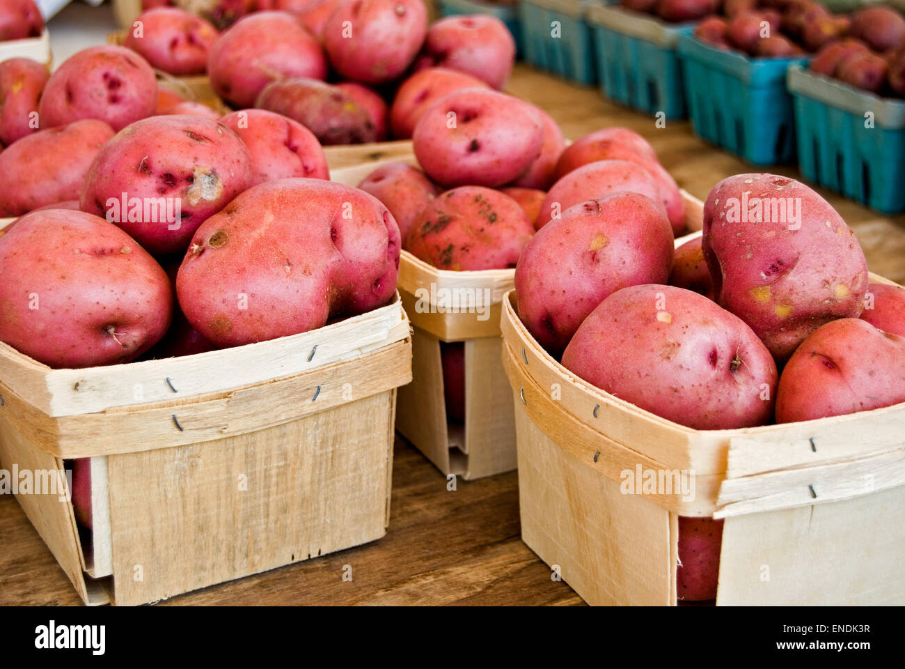 Red potatoes in wooden produce boxes. Stock Photo