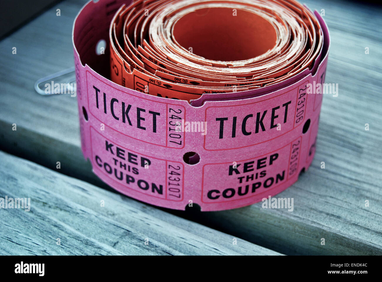 Roll of pink raffle tickets on wood. Stock Photo