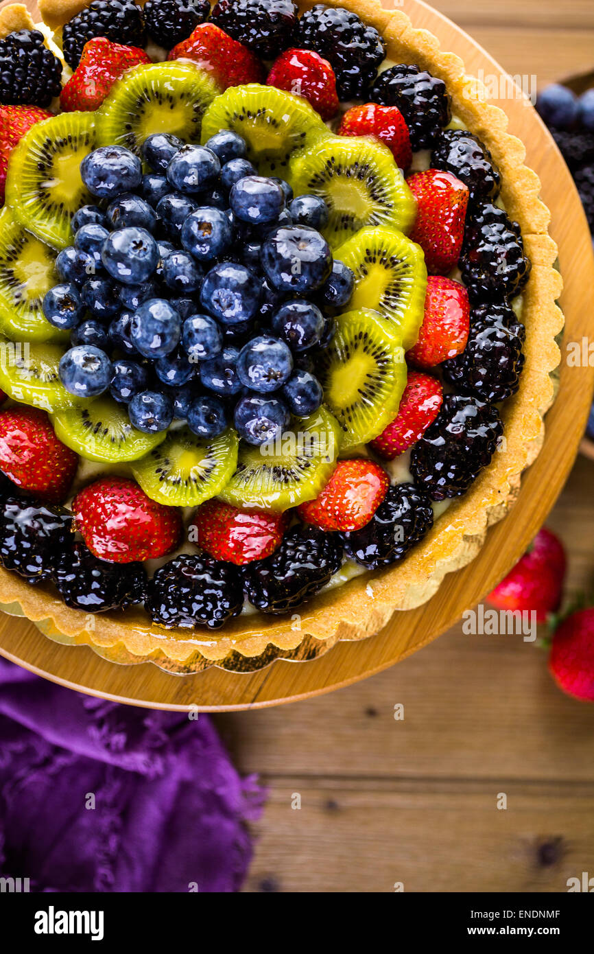 Fresh fruit tart on cake stand on wood table Stock Photo - Alamy