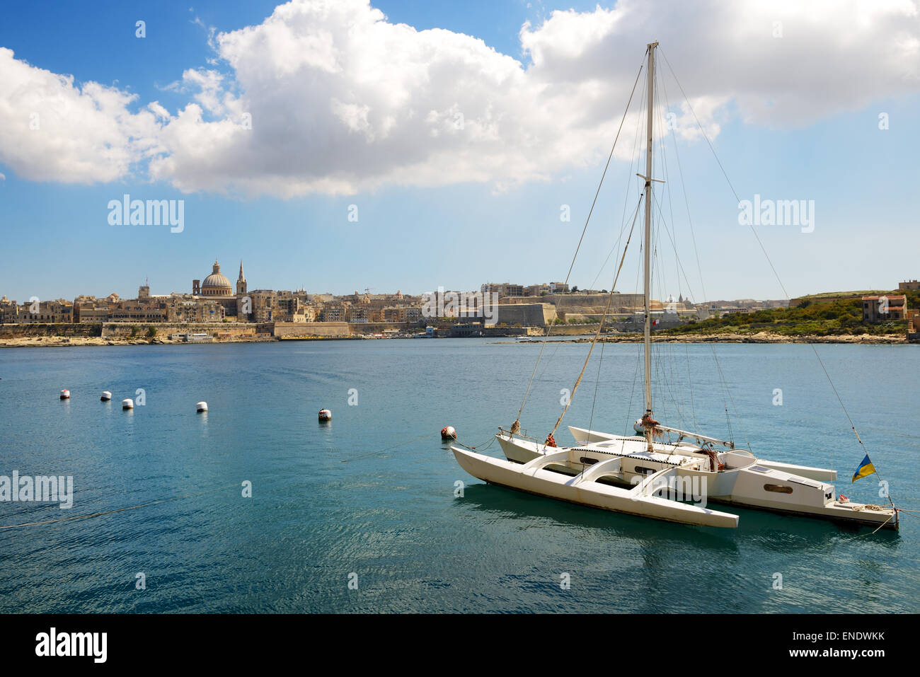 The view on Valletta and sail yacht with Ukrainian flag in sunset, Sliema, Malta Stock Photo