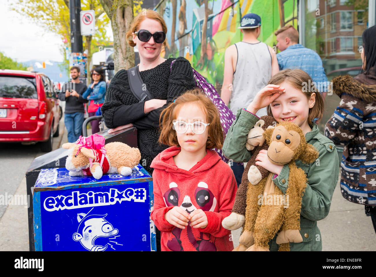 Young girls with stuffed animals enjoy watching the Earth Day Parade