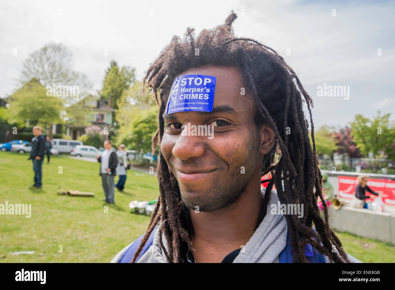 Young Afro-Canadian man with Stop Harper's Crimes sticker on his forehead. Vancouver, B.C. Canada Stock Photo