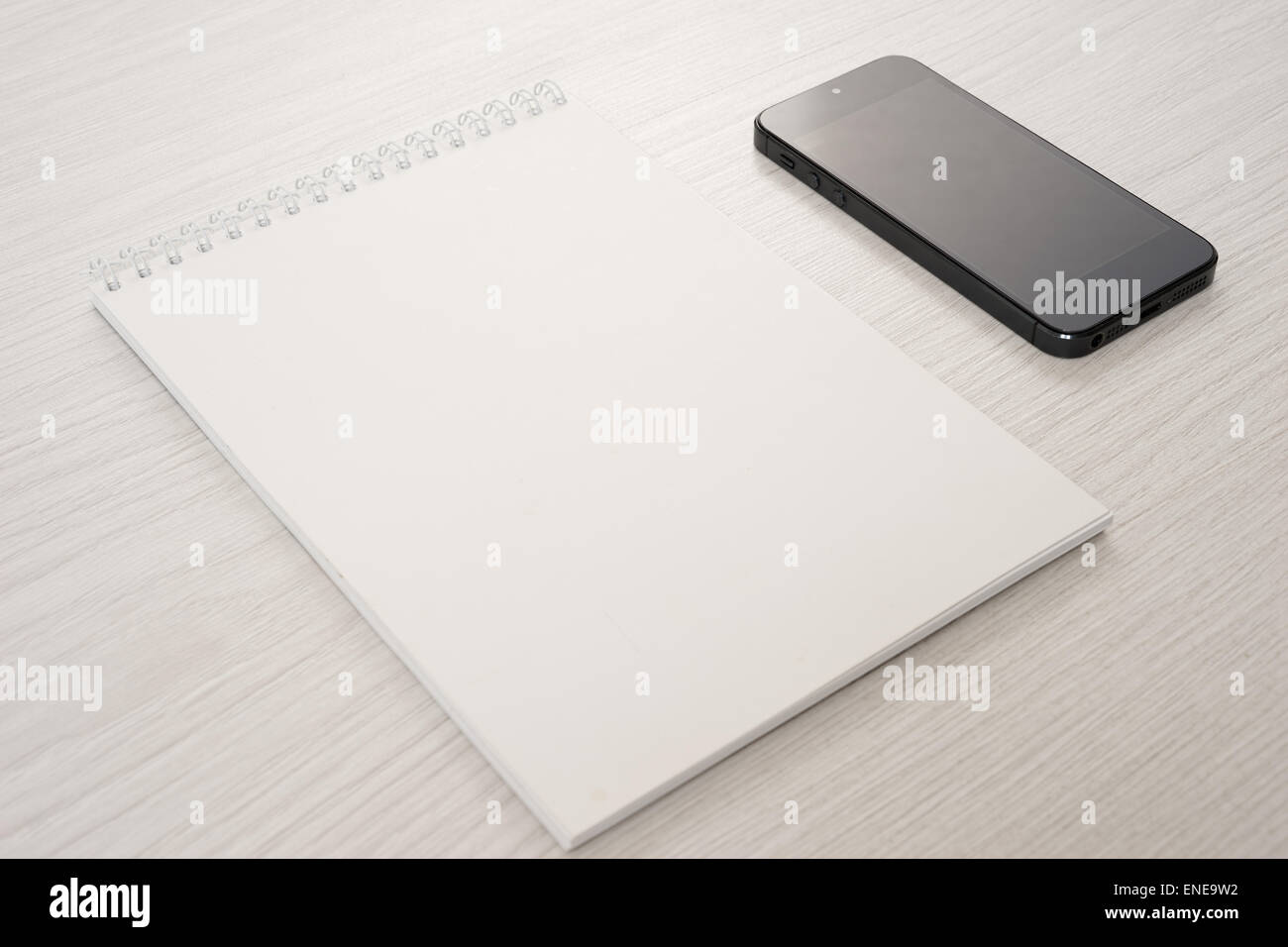 Notepad with the phone on a light table Stock Photo - Alamy