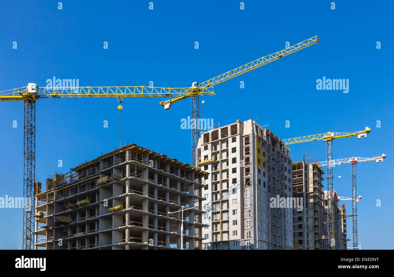 Construction cranes on building site on sky background Stock Photo - Alamy