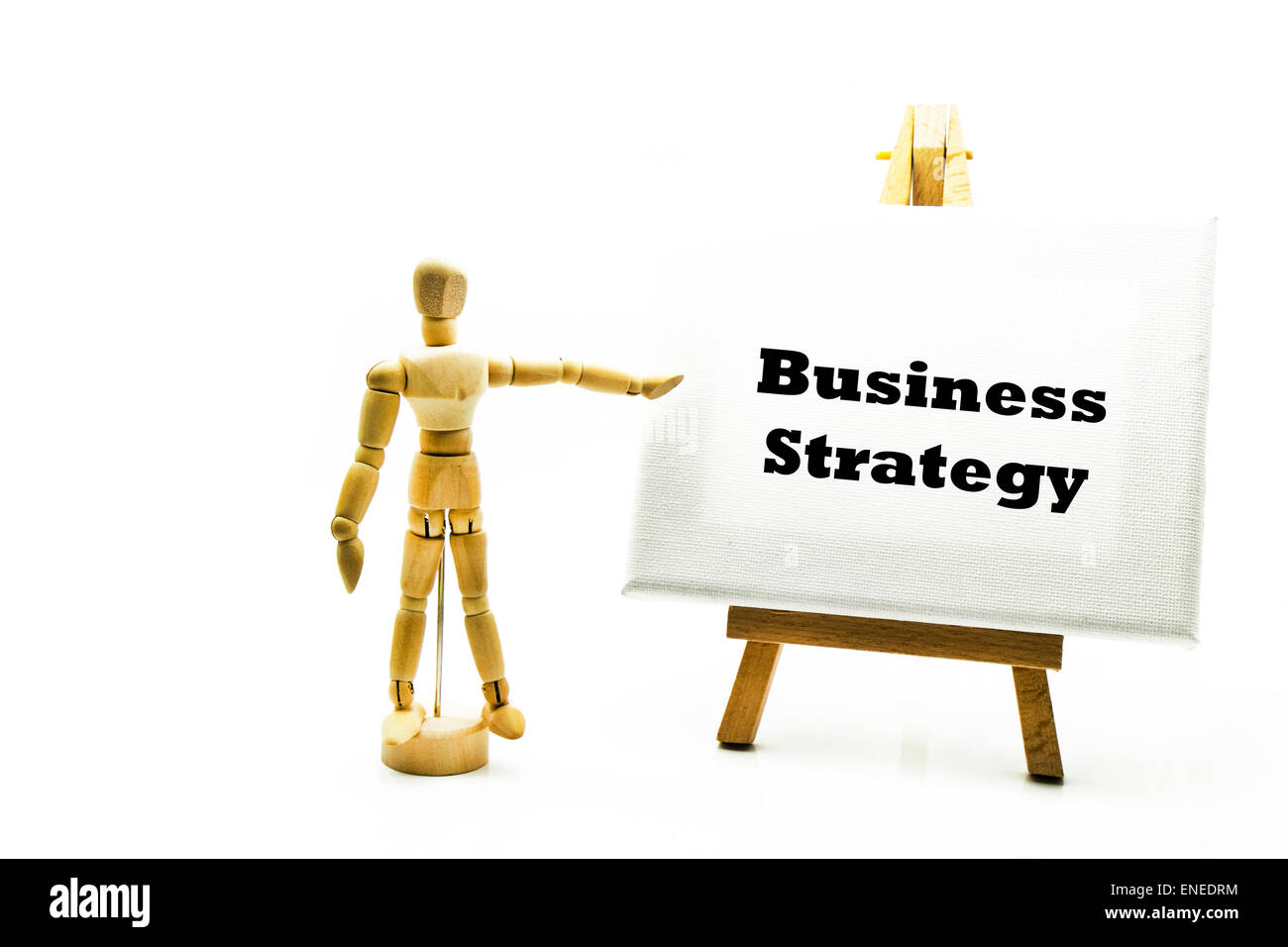 Wooden man with white board pointing at words 'business strategy' businesses strategies strategic progress best way forward Stock Photo