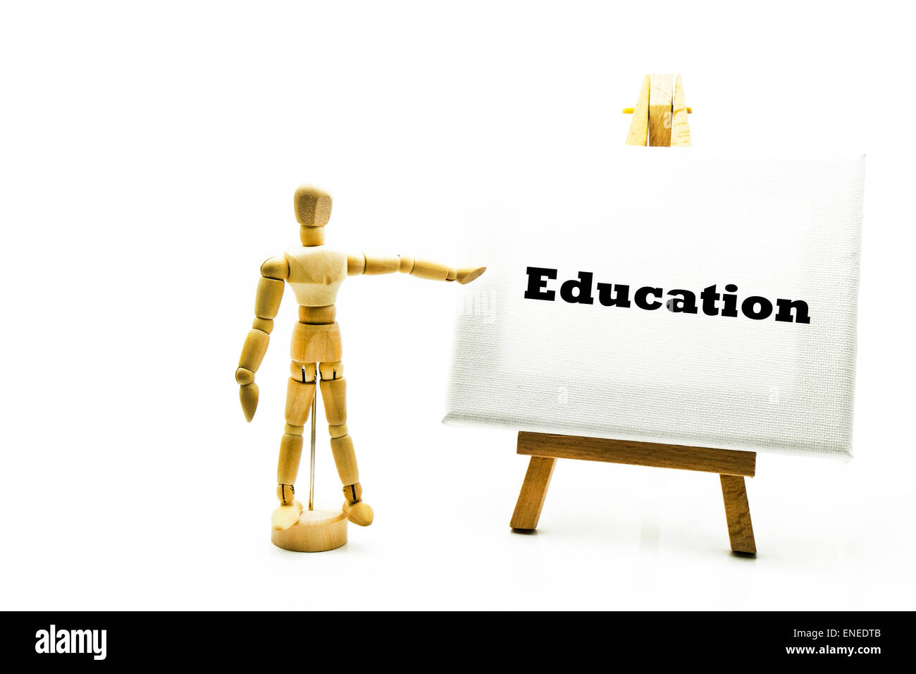 Wooden man with white board pointing at word Education schooling teach teaching future university schools Stock Photo
