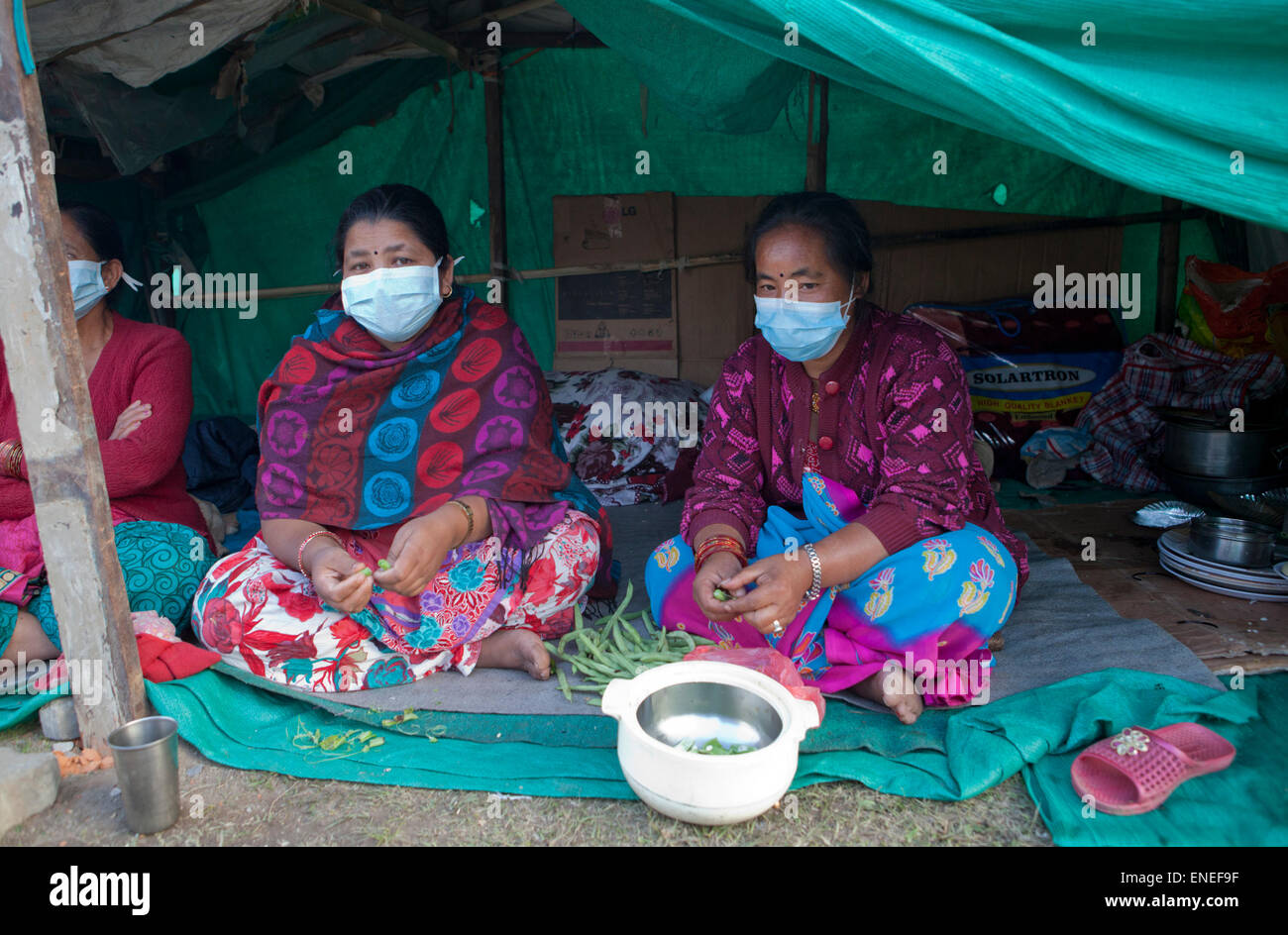 Nepal. 3rd May, 2015. Women sit around shelters at Tundikhel in Kathmandu. A major 7.9 earthquake hit Kathmandu mid-day on Saturday, April 25th, and was followed by multiple aftershocks that triggered avalanches on Mt. Everest that buried mountain climbers in their base camps. Credit:  PixelPro/Alamy Live News Stock Photo