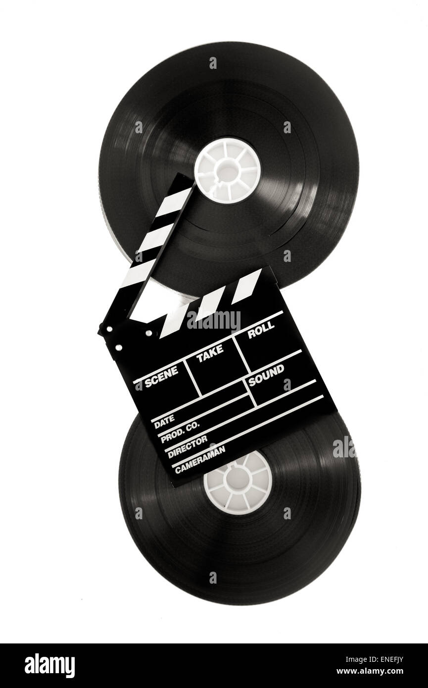 Movie clapper on 35 mm cinema film reels isolated on white
