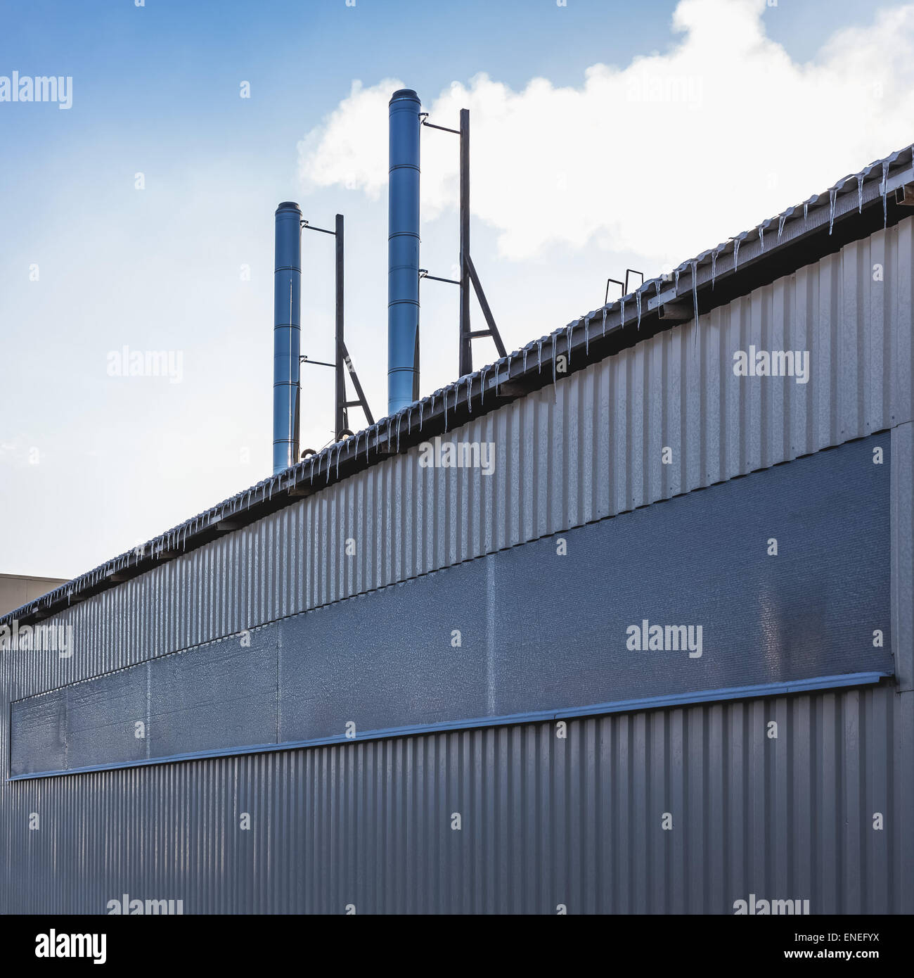 Plastic siding wall of industrial building with smoke pipes Stock Photo