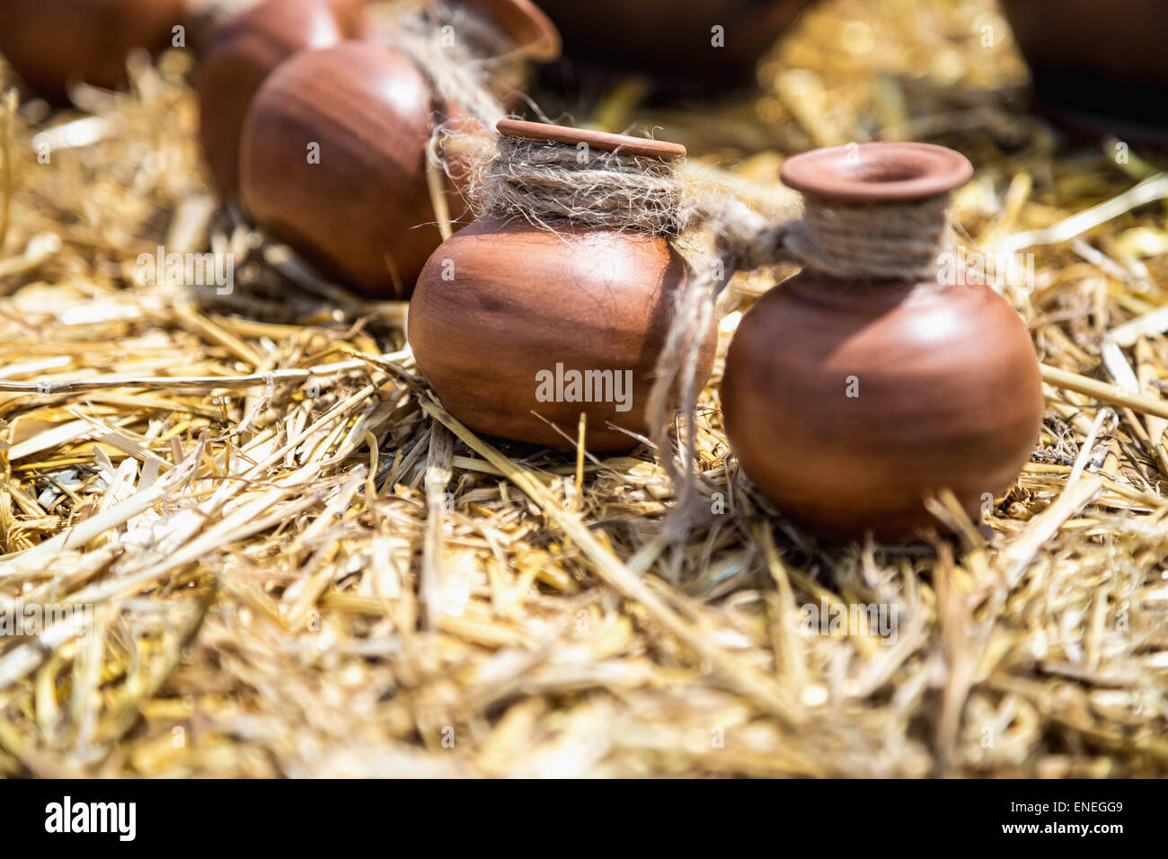 Small ceramic crocks or pot countryside decoration or souvenir on straw. Selective focus of image on one of crock Stock Photo
