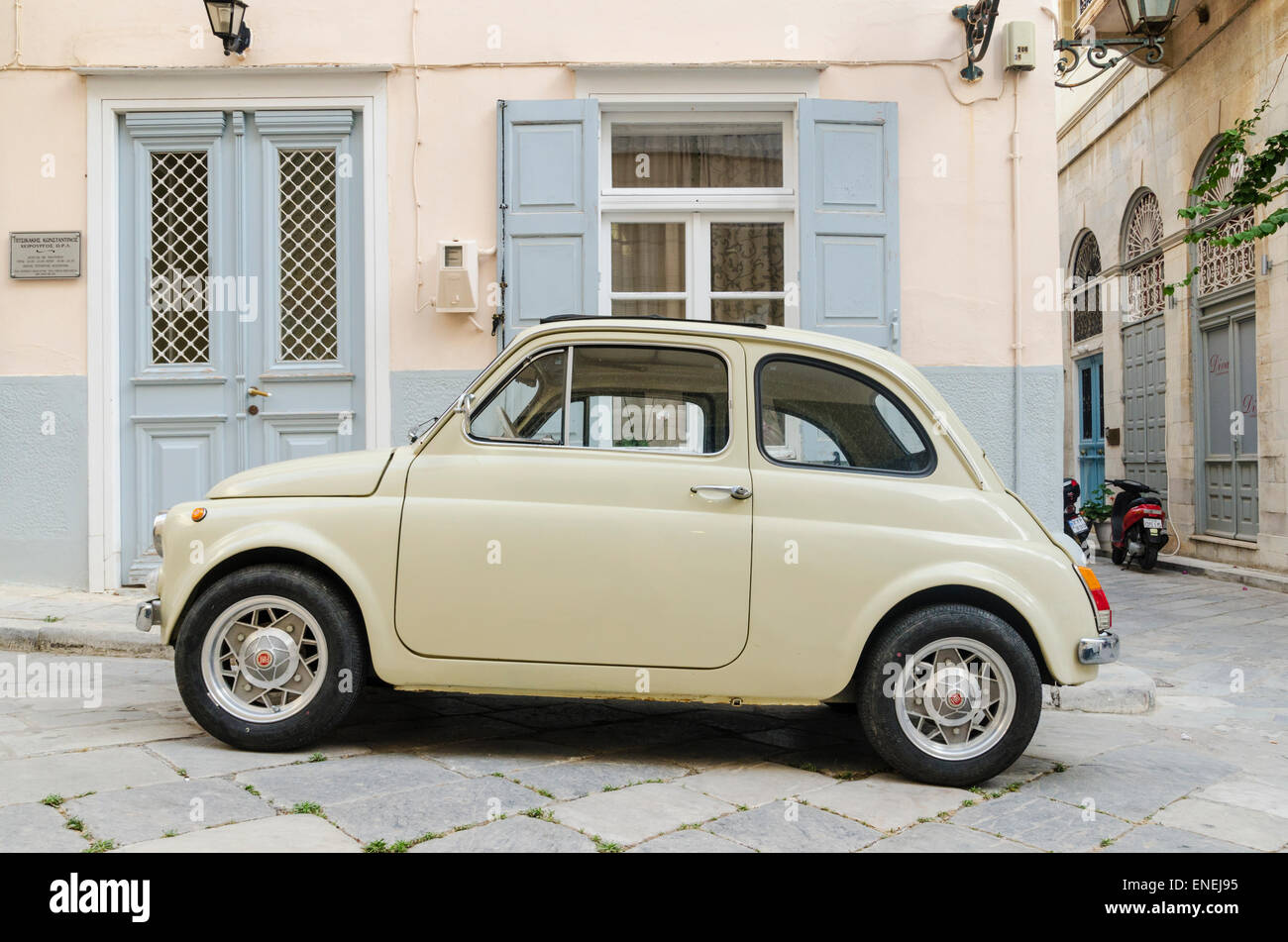 Cream coloured Fiat 500 parked outside a building on the Greek island of Syros Stock Photo