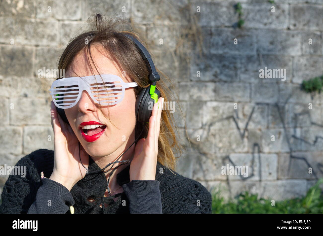 Happy crazy girl  listening to music wearing big sunglasses Stock Photo