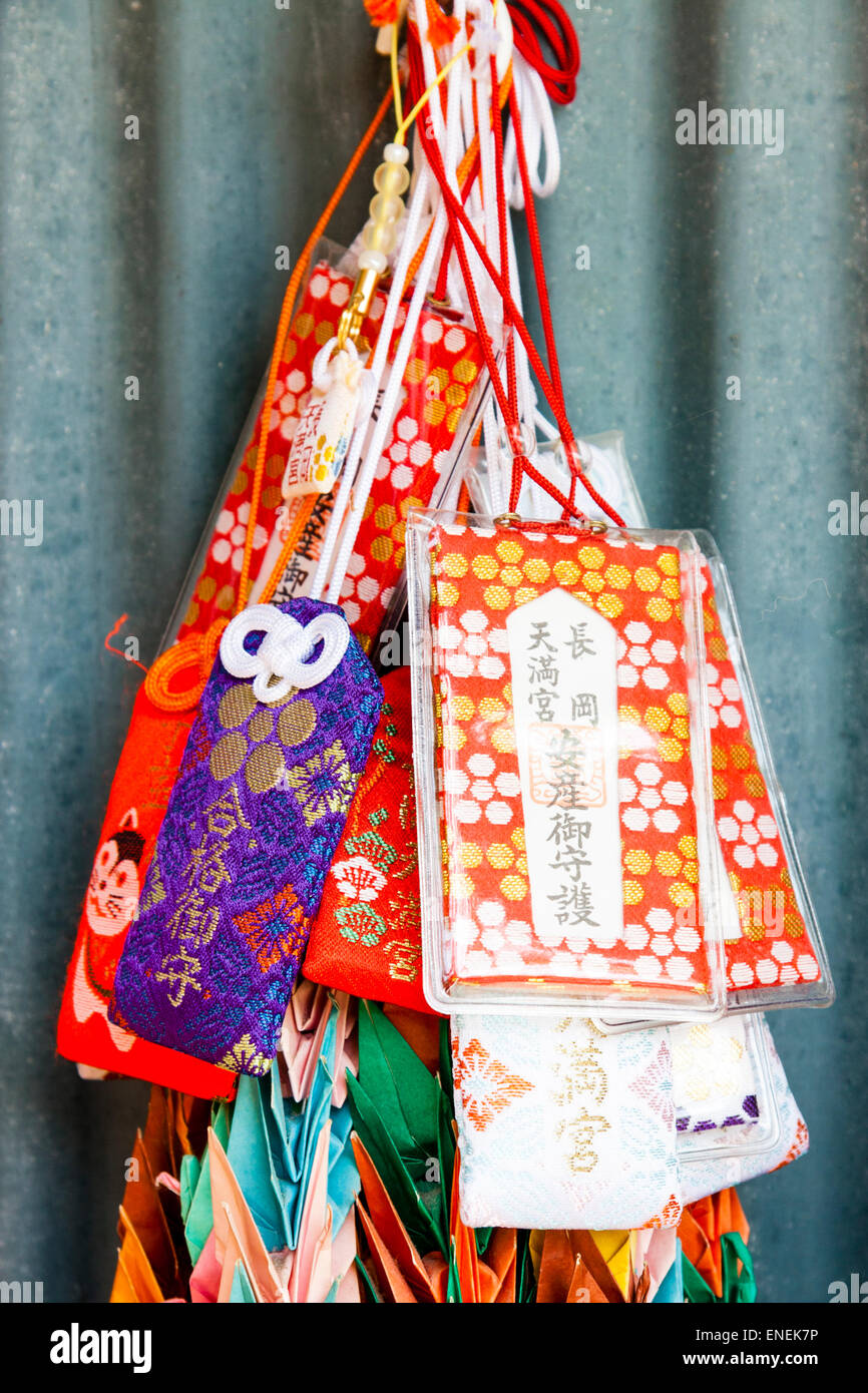 Several tiny drawstring like little bags, omamori, hanging at a