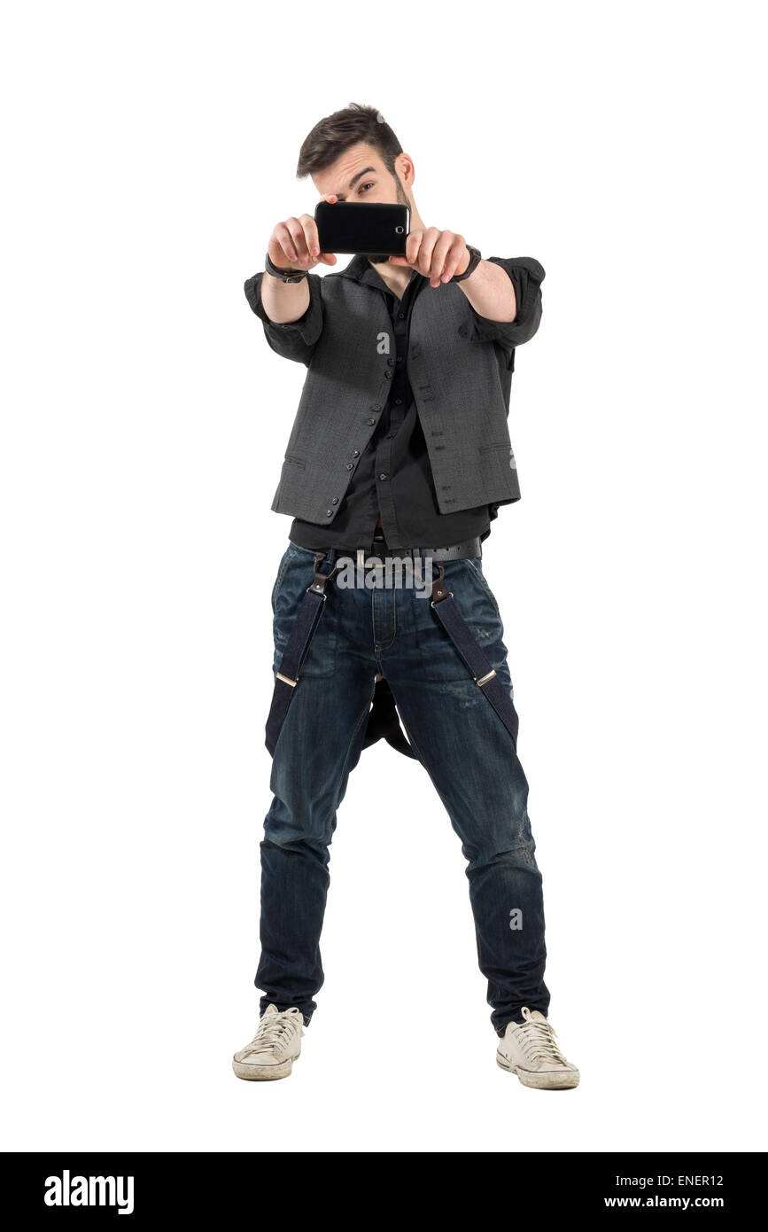 Front view of trendy young man taking photo with mobile phone. Full body length portrait isolated over white background Stock Photo