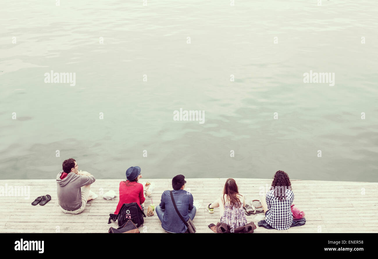 Students relaxing on pier. Plenty of copy space Stock Photo