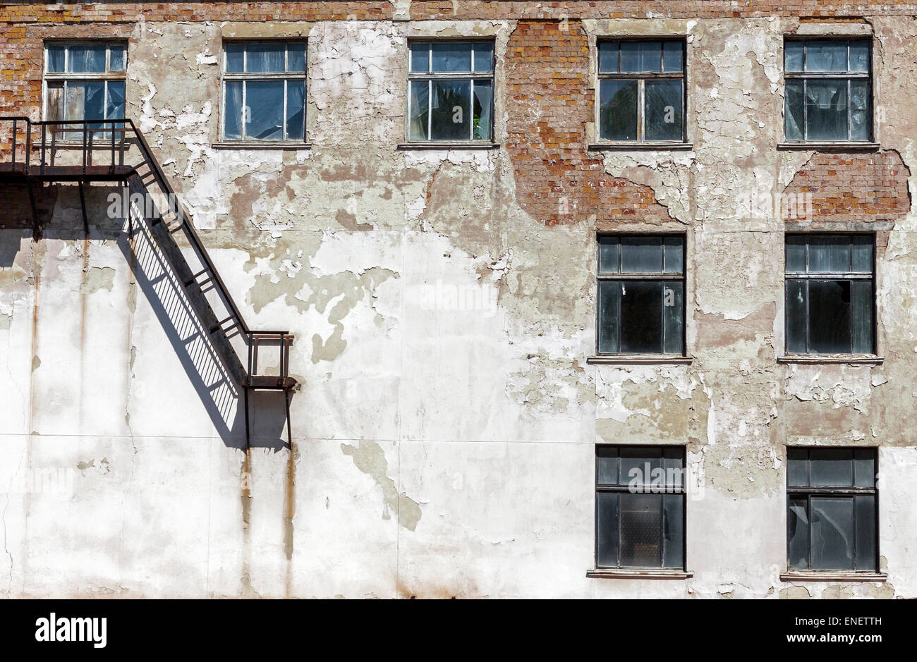 Grunge architecture details. Old abandoned factory with metal staircase and broken windows Stock Photo