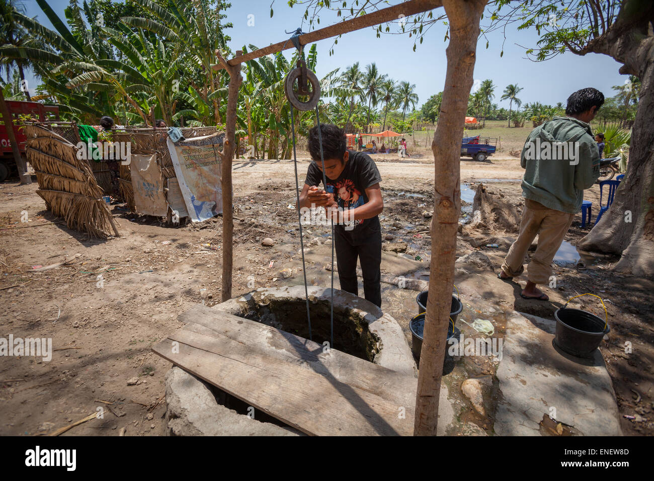 A young man taking water from a communal water well in Kawangu, Sumba, a dry island in East Nusa Tenggara, Indonesia. Stock Photo