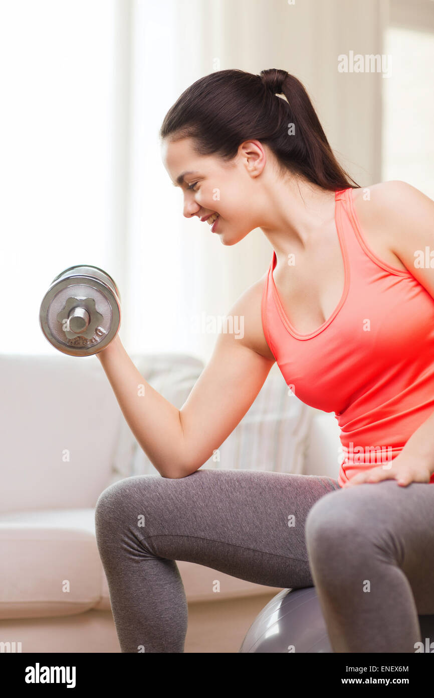 smiling girl exercising with dumbbells Stock Photo