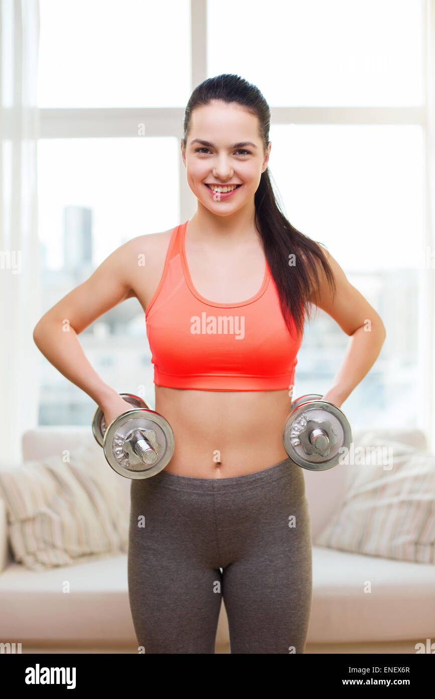 smiling girl exercising with dumbbells Stock Photo