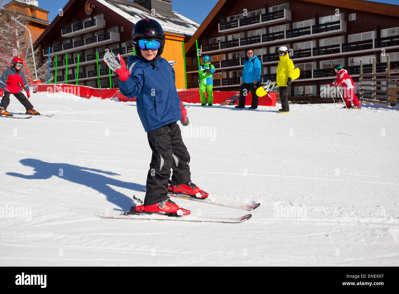 Young boy learning to ski in front of holiday chalets Stock Photo
