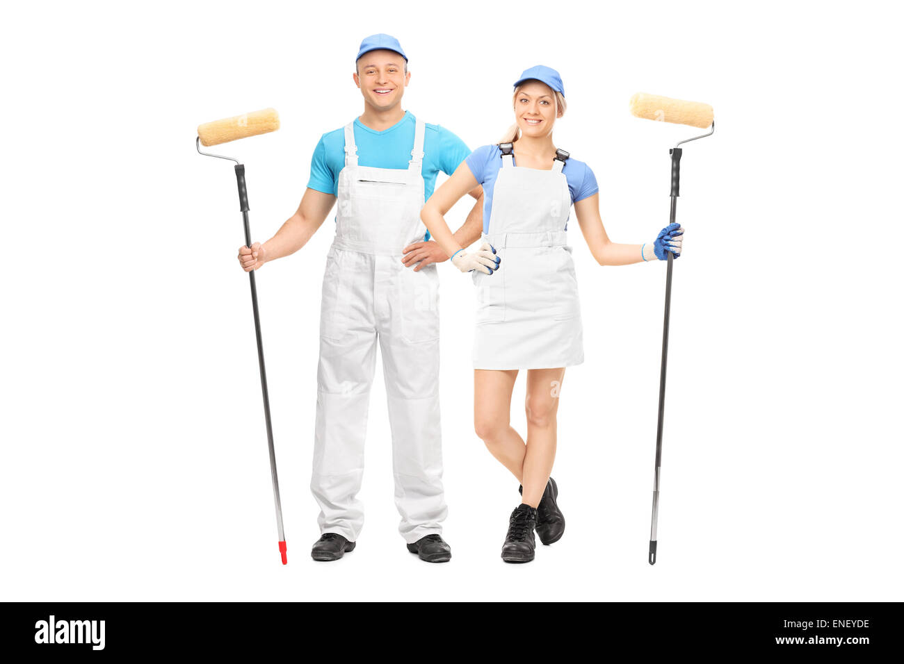 Male and a female house painters holding paint rollers and posing in