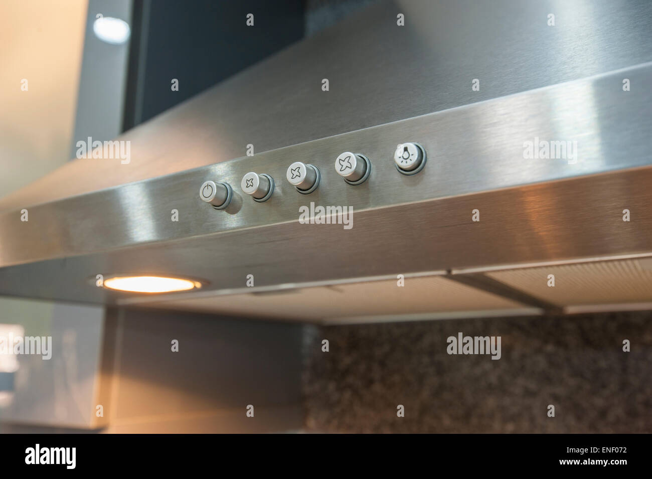 Closeup detail of buttons on metal cooker hood extractor fan with spotlight in luxury kitchen Stock Photo