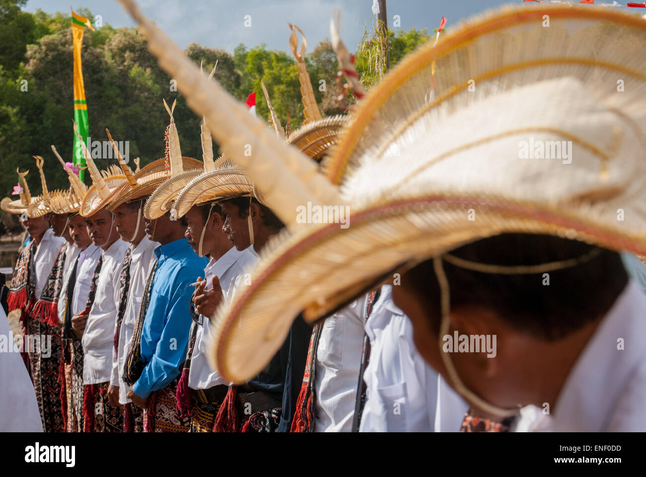 Men wearing traditional attire standing in a line during a preparation of a ceremony to release snake-necked turtles in Rote Island, Indonesia. Stock Photo