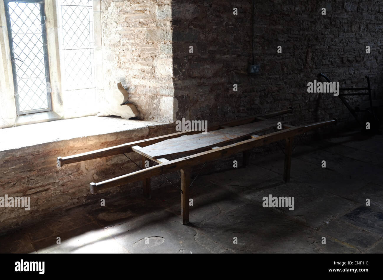 Old wooden coffin bier in a country church, lit by a window Stock Photo