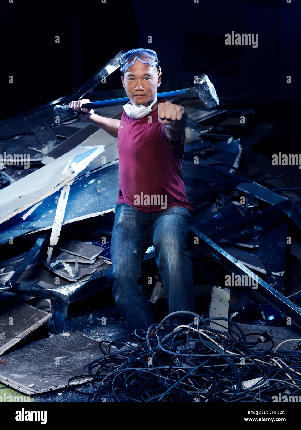 Humorous portrait of a man with a sledgehammer in a Kung Fu stance doing demolition work Stock Photo