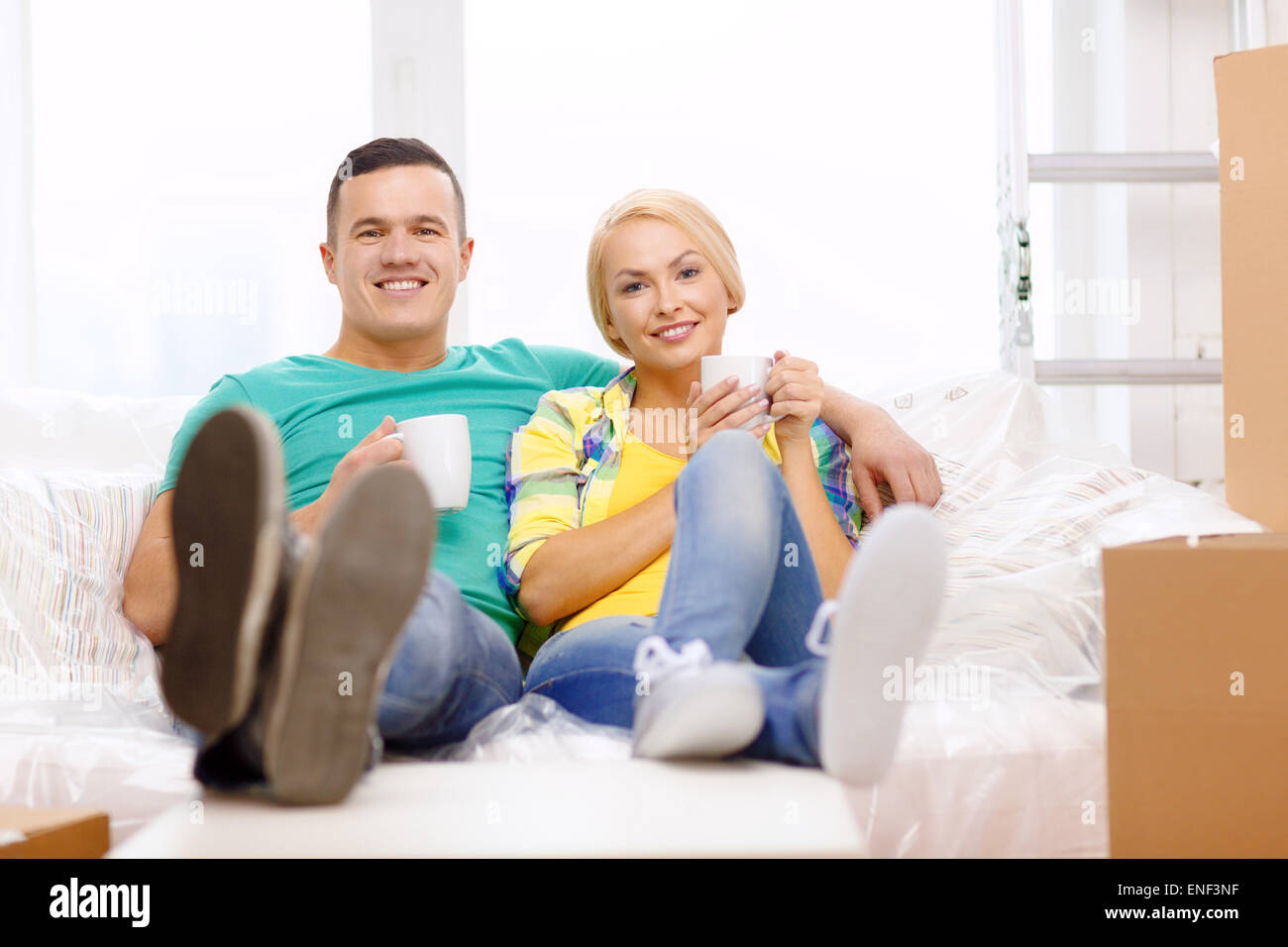 smiling couple relaxing on sofa in new home Stock Photo - Alamy