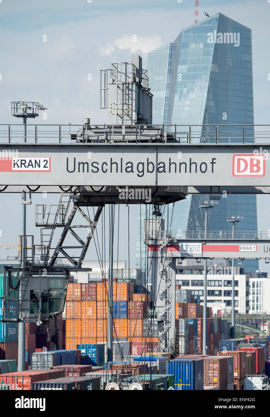 Frankfurt, Germany. 28th Apr, 2015. Containers are loaded from a truck onto tracks at a transshipment station in Frankfurt, Germany, 28 April 2015. Inbound containers are immediately loaded onto trains and trucks or stored temporarily in an open space area, based on a sophisticated logistics system. The headquarters of the European Central Bank (ECB) is pictured in the background. Photo: Boris Roessler/dpa/Alamy Live News Stock Photo