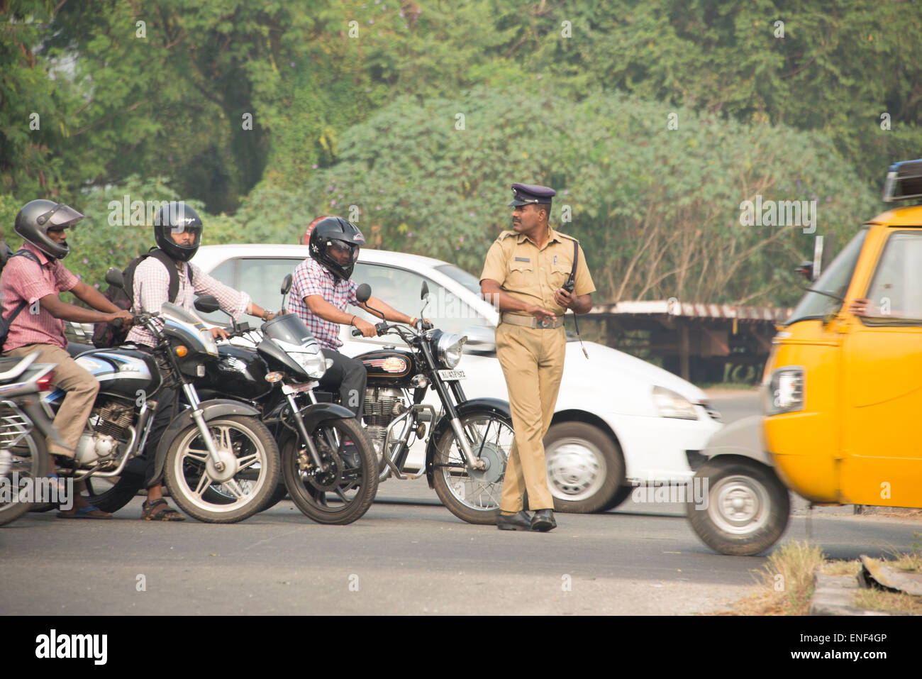 A traffic Police officer trying his best to control the flow of disorganised traffic at a busy cross-road in c Stock Photo