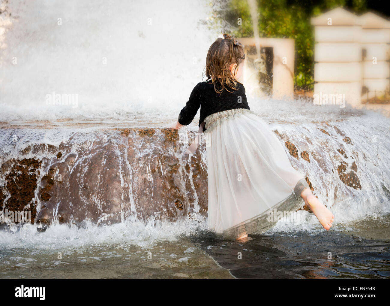 Little girl playing in a fountain Stock Photo - Alamy