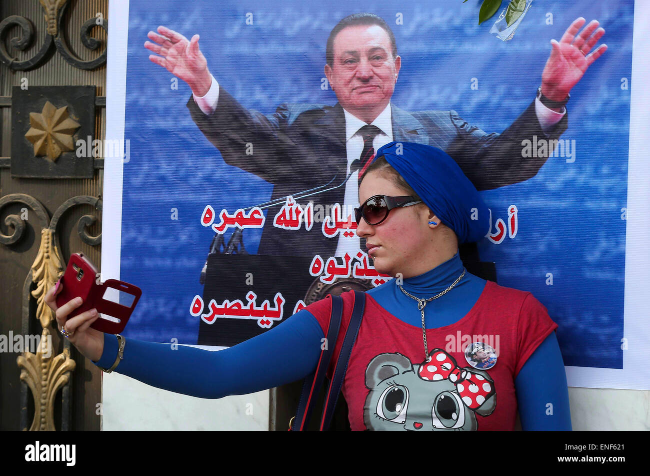 Cairo, Egypt. 4th May, 2015. An Egyptian supporter of former President Hosni Mubarak takes a selfie with his picture during a celebration to mark his 87th birthday, outside Maadi military hospital, near Cairo on May 4, 2015. An Egyptian legal authority on Monday ruled in favor of former President Hosni Mubarak by allowing him to retain his ''privileges'' as former president, a judicial source has said © Amr Sayed/APA Images/ZUMA Wire/Alamy Live News Stock Photo