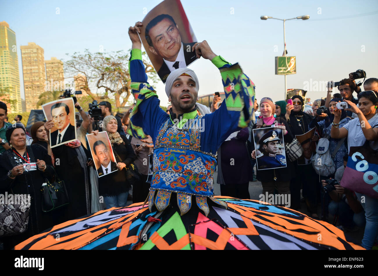 Cairo, Egypt. 5th May, 2015. A dancer performs as supporters of former President Hosni Mubarak holds his picture during a celebration to mark his 87th birthday, outside Maadi military hospital, near Cairo on May 4, 2015. An Egyptian legal authority on Monday ruled in favor of former President Hosni Mubarak by allowing him to retain his 'privileges' as former president, a judicial source has said © Amr Sayed/APA Images/ZUMA Wire/Alamy Live News Stock Photo