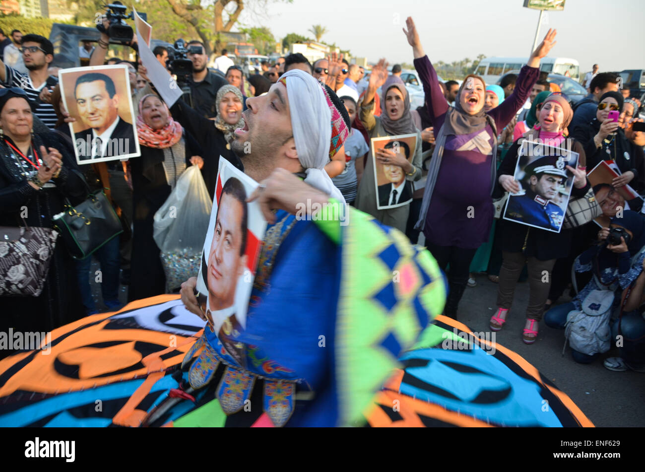Cairo, Egypt. 5th May, 2015. A dancer performs as supporters of former President Hosni Mubarak holds his picture during a celebration to mark his 87th birthday, outside Maadi military hospital, near Cairo on May 4, 2015. An Egyptian legal authority on Monday ruled in favor of former President Hosni Mubarak by allowing him to retain his 'privileges' as former president, a judicial source has said © Amr Sayed/APA Images/ZUMA Wire/Alamy Live News Stock Photo